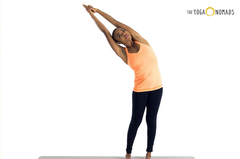 The image shows an individual performing a side stretch yoga pose against a white background. The person is standing with feet together, one arm extended overhead with the hand reaching towards the opposite side, and the other arm down along the body. This pose demonstrates a common stretching position that can help improve flexibility and reduce muscle tension.